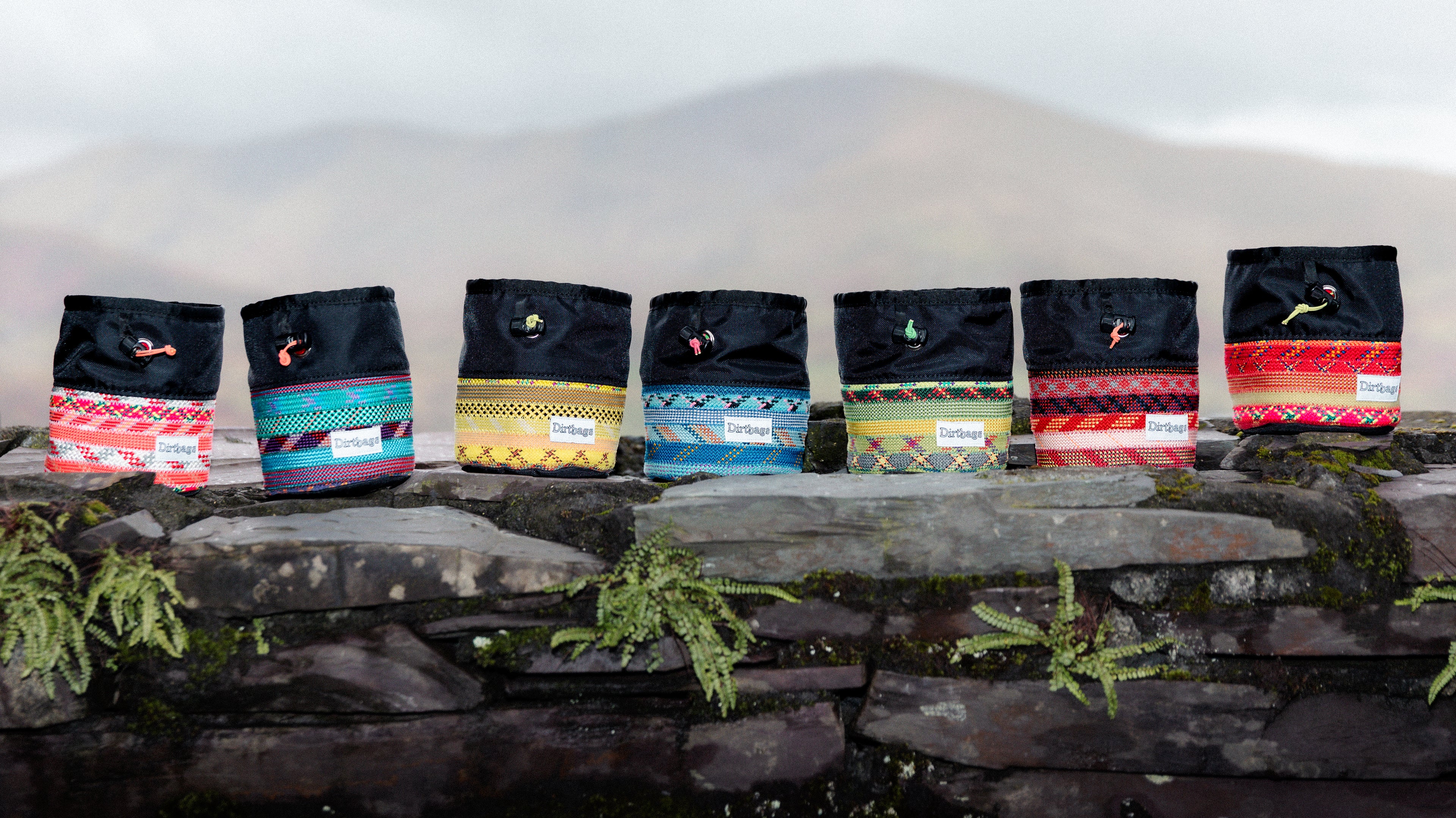 Set of colorful bags with patterns on a stone ledge in Llanberis