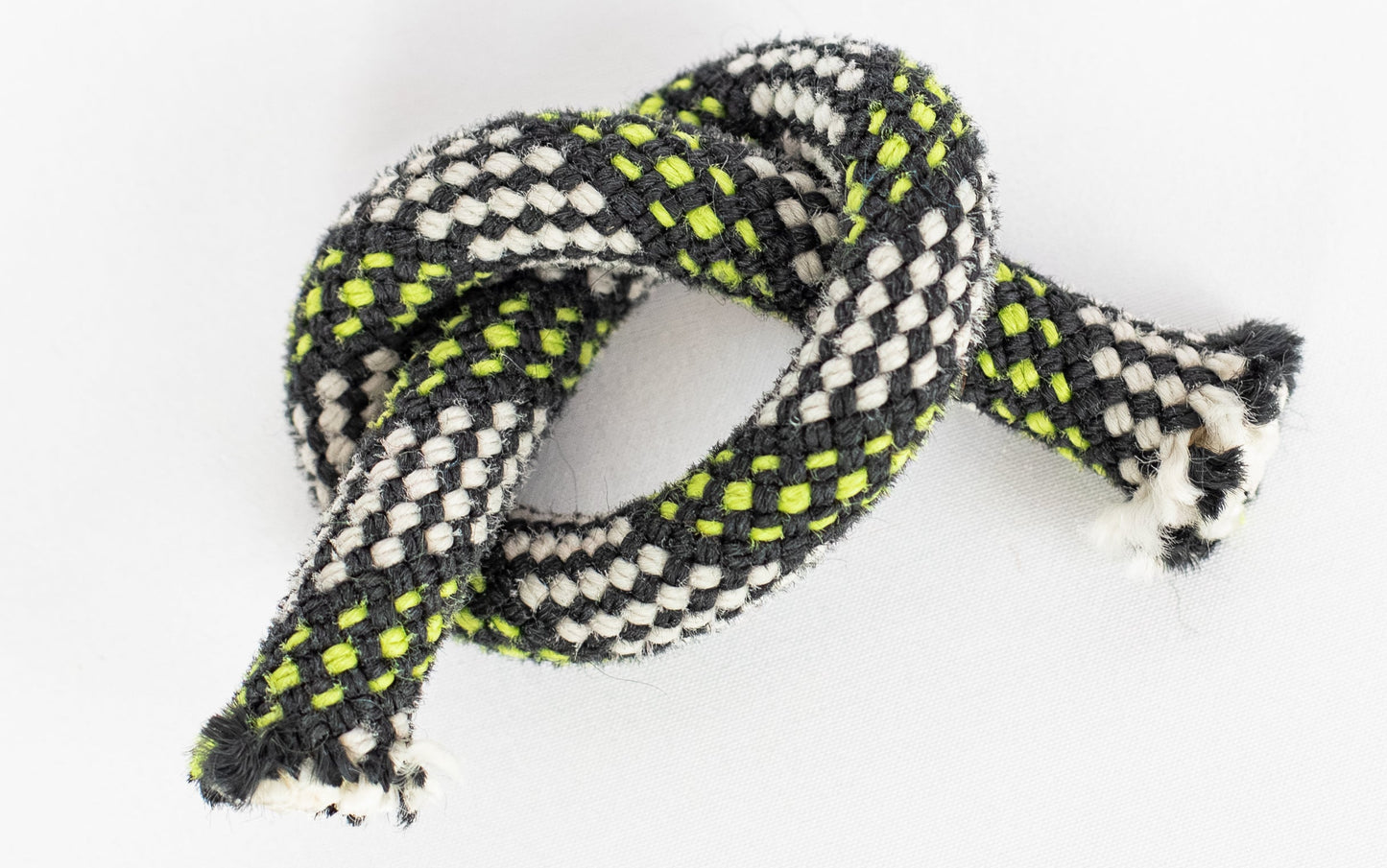 Tangled black and white rope with green accents on a white background