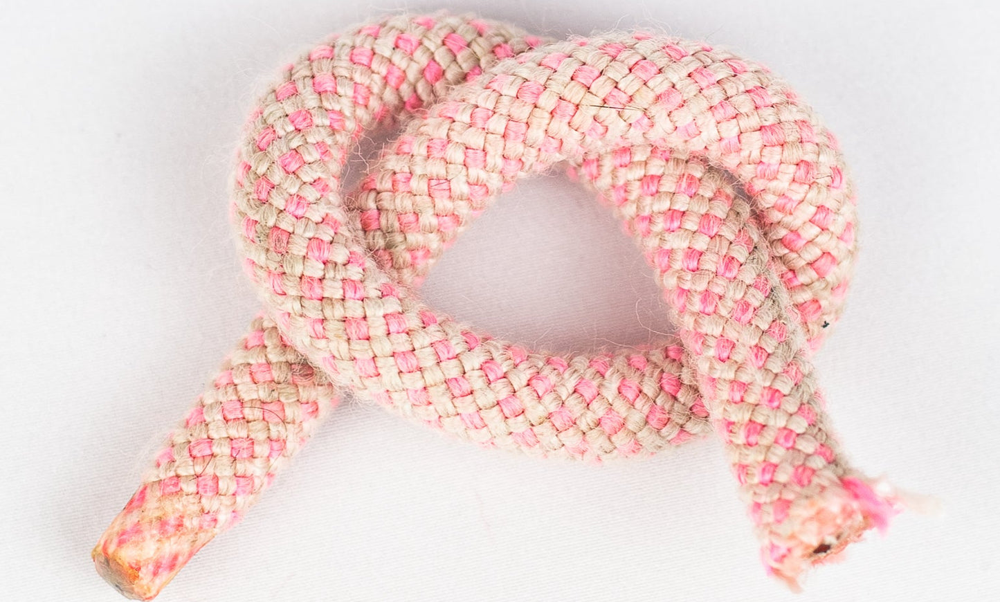 Pink braided rope on a white background