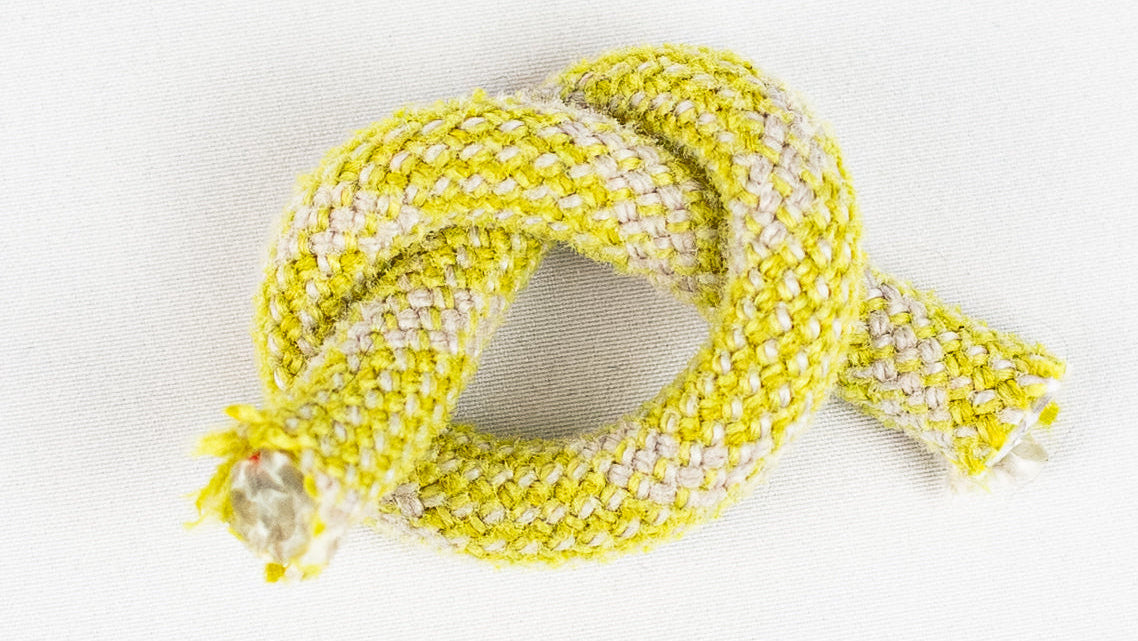 Yellow and white braided cord on a light gray background