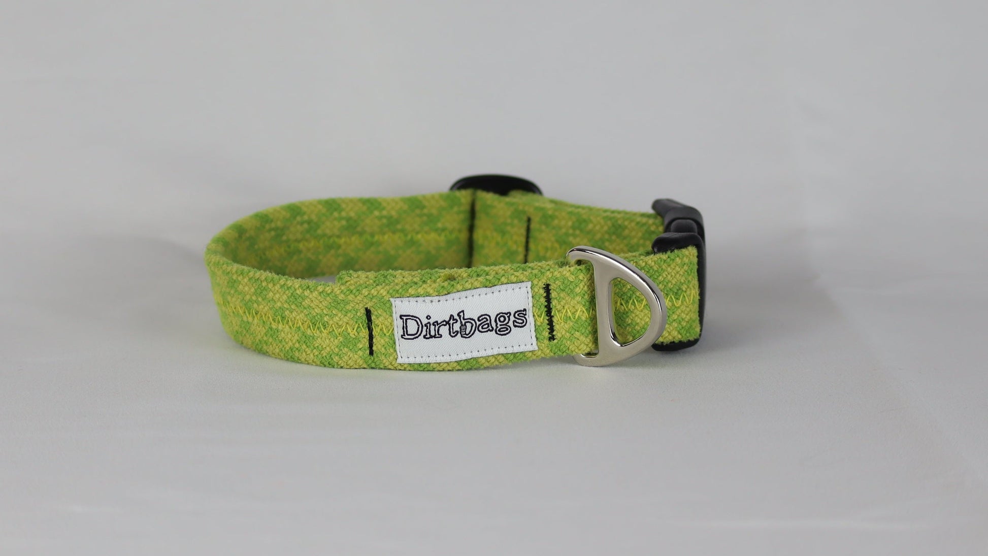 Green dog collar with a brand tag on a gray background
