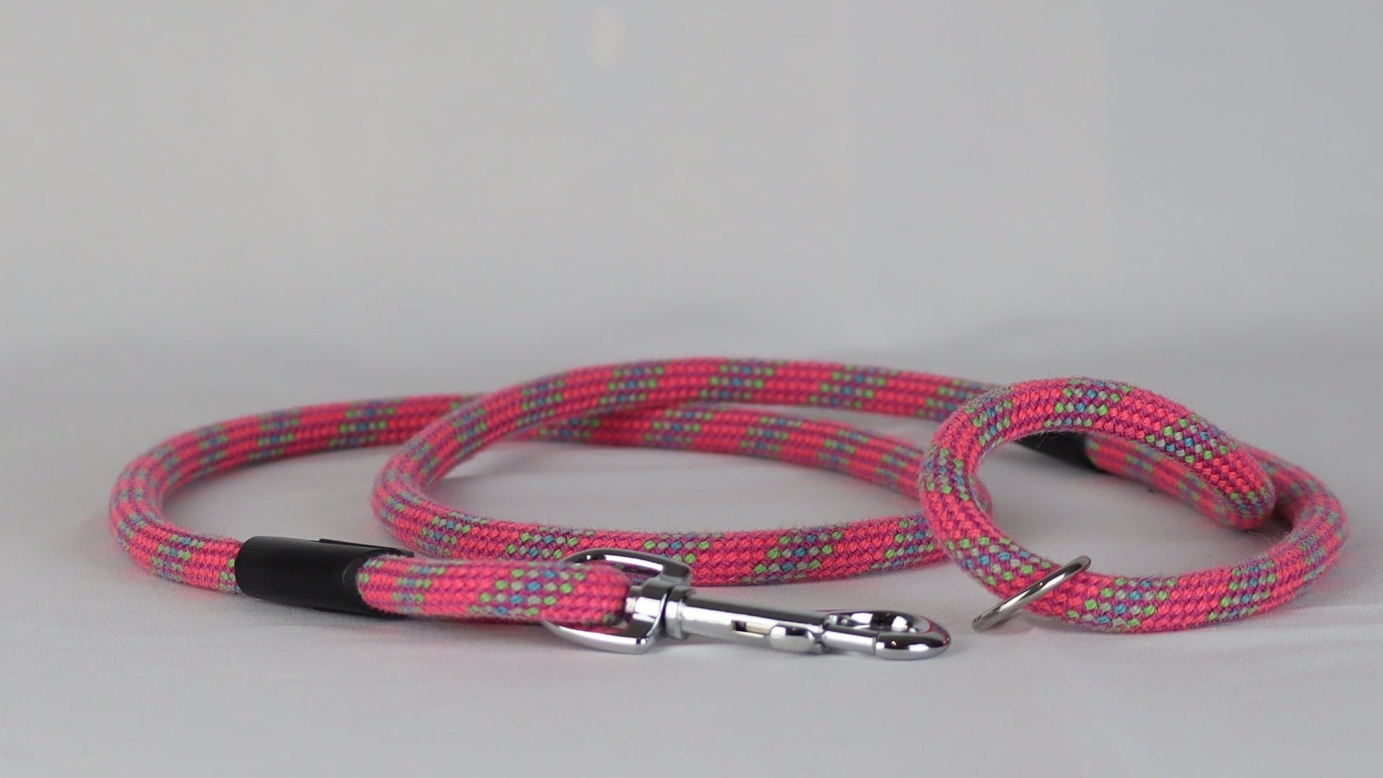Pink and gray braided dog leash on a white background